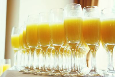 Close-up of orange juices in wineglasses on table