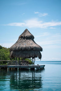 Hut by sea against sky