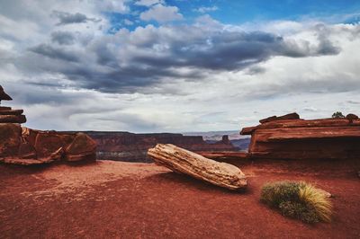 Rock formations on landscape against cloudy sky