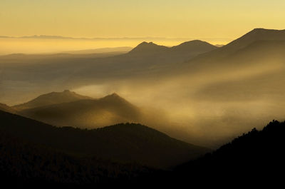 Scenic view of silhouette mountains against sky during sunset