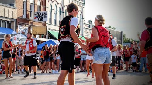 Young woman holding hands while walking on sidewalk