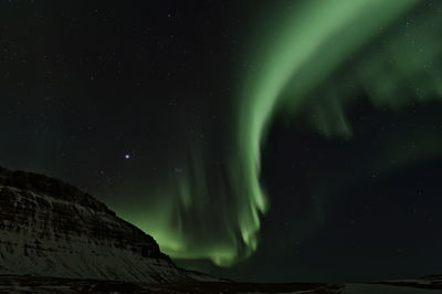 Low angle view of aurora borealis at night during winter