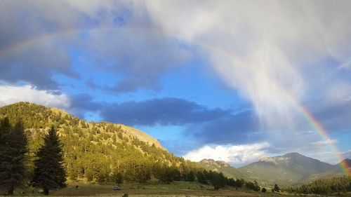 Scenic view of rainbow over mountains against sky