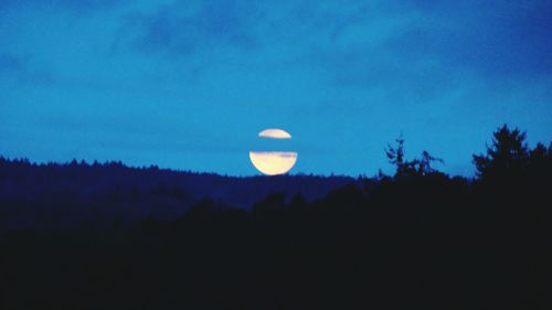 Low angle view of moon against blue sky