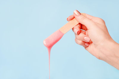 Cropped image of hand holding hair removal wax