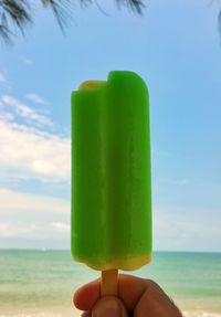 Person holding ice cream cone on beach