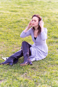 Full length of woman sitting on field