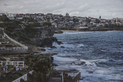 Buildings by sea against sky in city