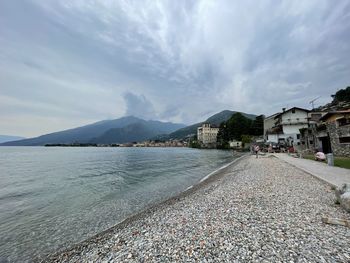 Scenic view of beach by buildings against sky