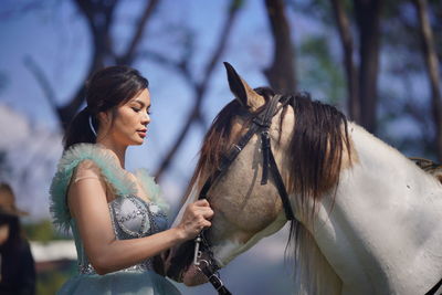 Low angle view of young woman riding horse