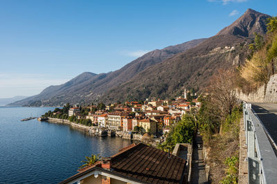 Scenic view of sea and mountains against clear blue sky