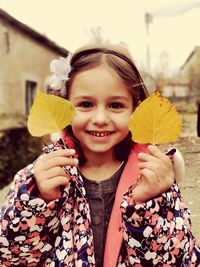 Portrait of smiling girl holding leaves