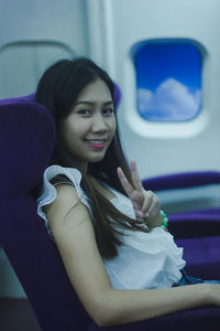 Portrait of a smiling young woman in train