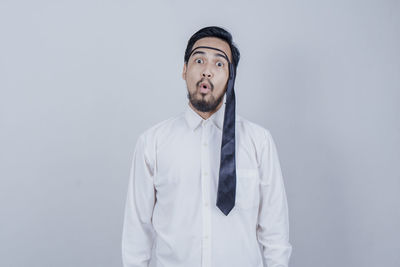 Portrait of man standing against white background