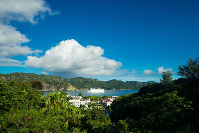 Cruise ship in sea by mountains against sky