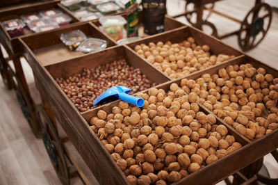 Large mature walnuts in a wooden box for purchase with a bucket