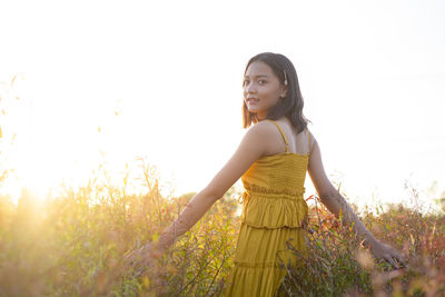 Full length of woman standing on field against clear sky