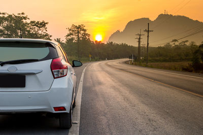 Car on road against sky during sunset