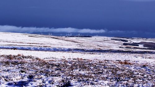 Snow covered landscape against sky