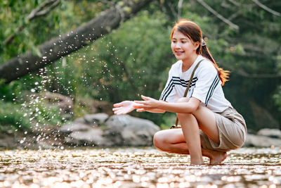 Happy young woman sitting outdoors