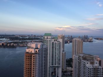 Aerial view of city against cloudy sky