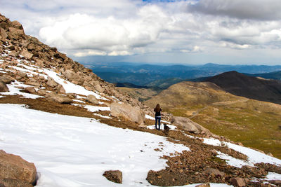 Rear view of man standing on snow covered mountain in colorado 