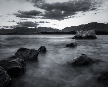 Rocks on sea shore against sky