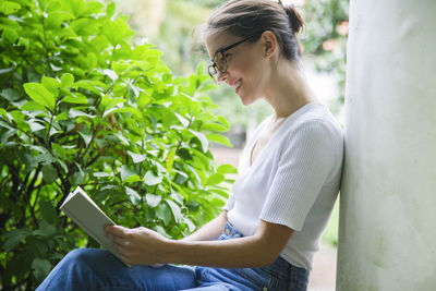 Side view of young woman using mobile phone