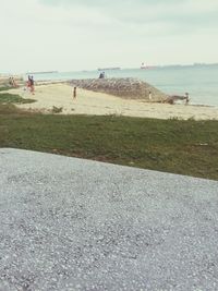 People at beach against sky