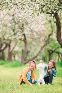 Two people on grass against trees