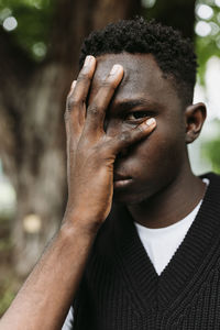 Young african man sad with facepalm gesture, looking through fingers