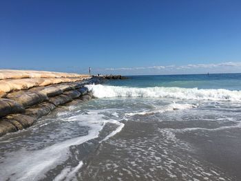 Scenic view of beach against blue sky