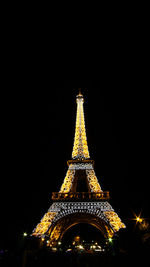 Low angle view of illuminated tower against sky at night