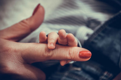 Close-up of father holding baby hand