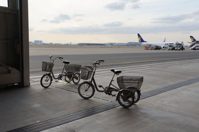 Tricycles at airport against sky during sunset