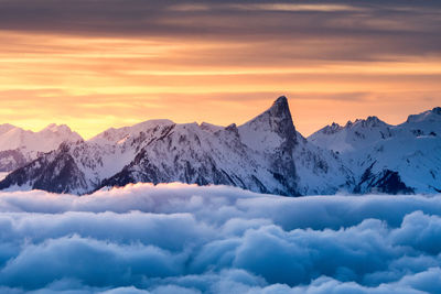 Scenic view of snowcapped mountains against sky during sunset