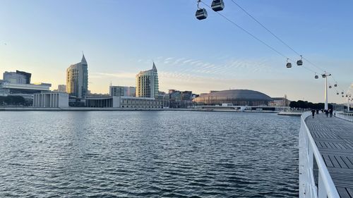 Sea by buildings against sky in city