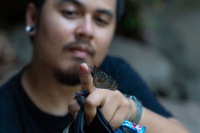 Close-up of man holding butterfly