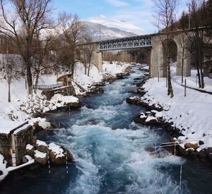 Bridge over river during winter