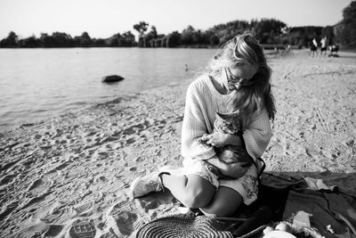 Rear view of woman sitting on beach