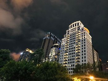 Low angle view of illuminated buildings against sky at night