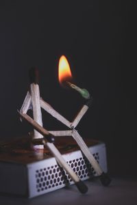 Close-up of candles on table against black background