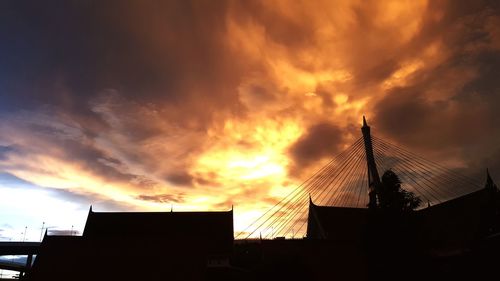 Low angle view of silhouette building against sunset sky