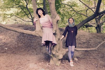 Full length portrait of happy girl standing in forest