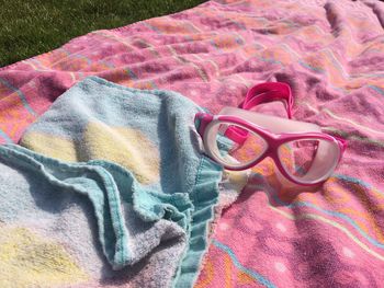 Close-up of swimming goggles and towels on grass