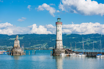 Lighthouse by sea against sky