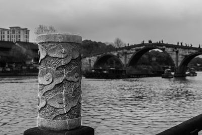 Bridge over river in city against sky