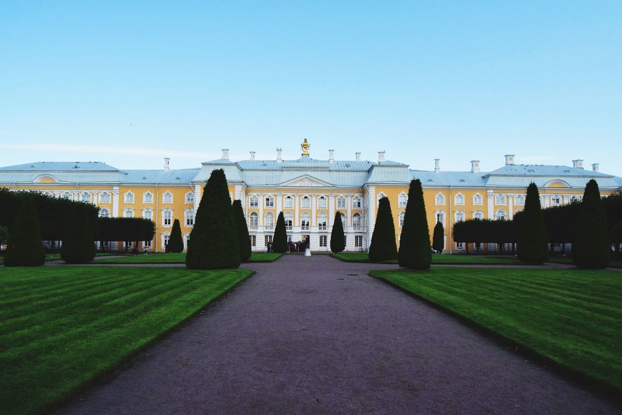 built structure, architecture, clear sky, copy space, history, grass, travel destinations, outdoors, day, building exterior, the way forward, no people, sky, tree, nature