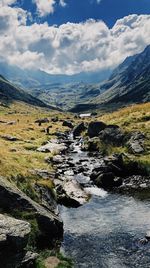 Scenic view of river amidst mountains against sky