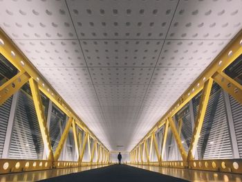 Silhouette of man standing on elevated walkway